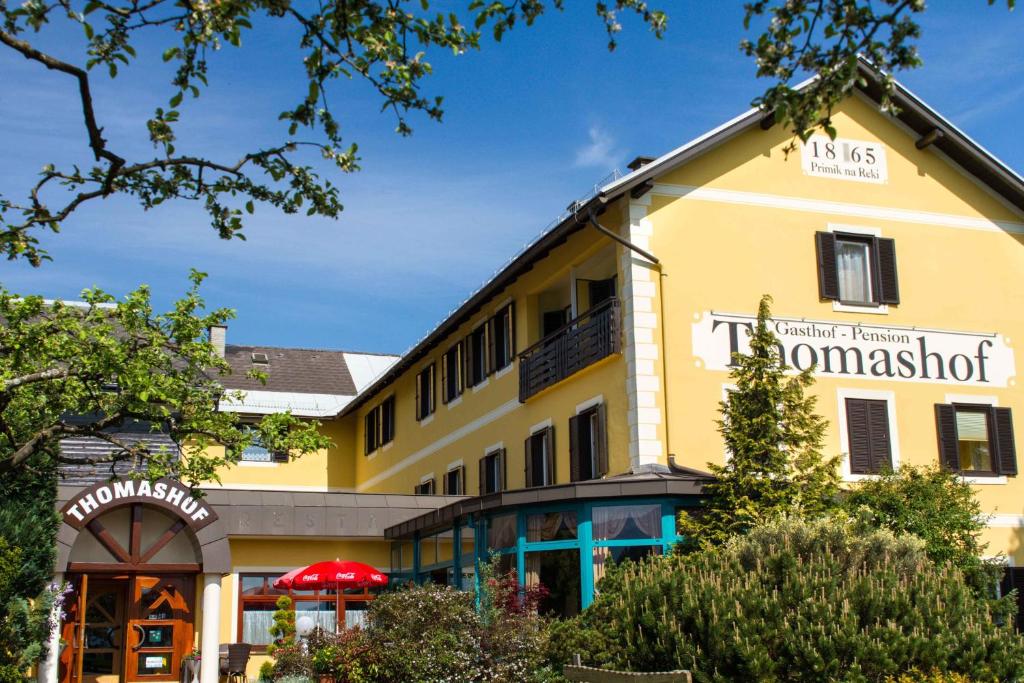 a yellow building with a sign for a restaurant at Der Thomashof in Sankt Jakob im Rosental