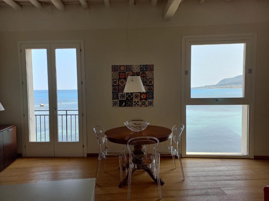 una sala da pranzo con tavolo e vista sull'oceano di A Casa di Clara a Trapani