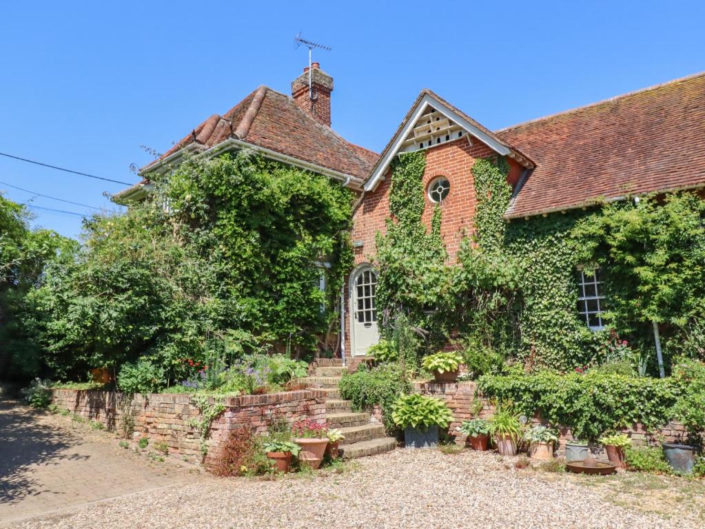 an old brick house with ivy on it at The Gate House in Colchester