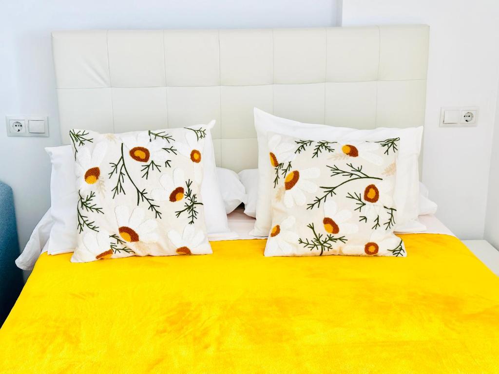 Una cama con dos almohadas con naranjas. en Iris Vistas Sea & Sun Benalmadena, en Benalmádena