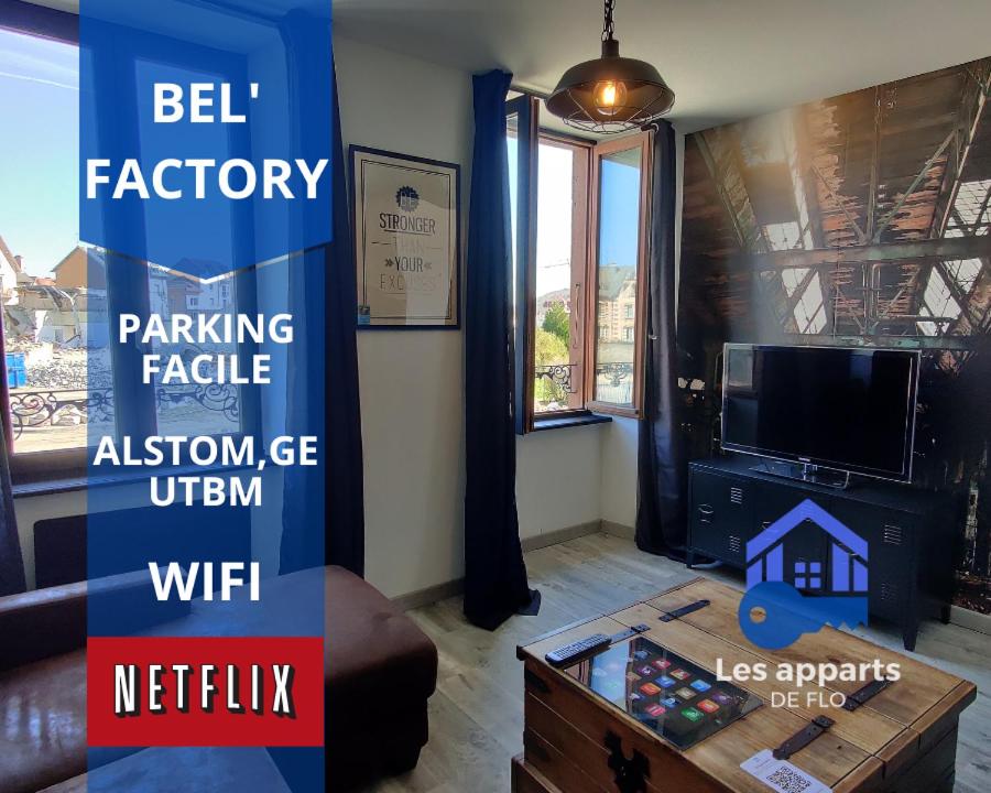 una sala de estar con un cartel que dice fábrica de bolas y una mesa en Les Studios De Flo' : The Bel'Factory 38 m² WIFI, en Belfort