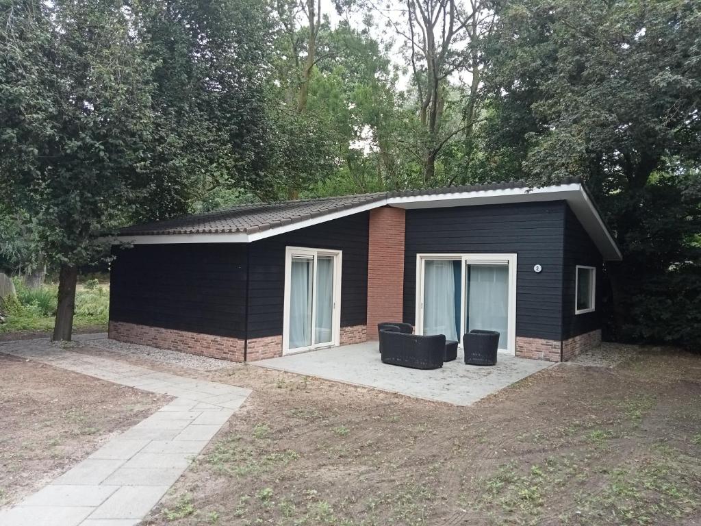 a black shed with two windows and a driveway at Domstad Resort Utrecht Vakantiewoningen in Utrecht