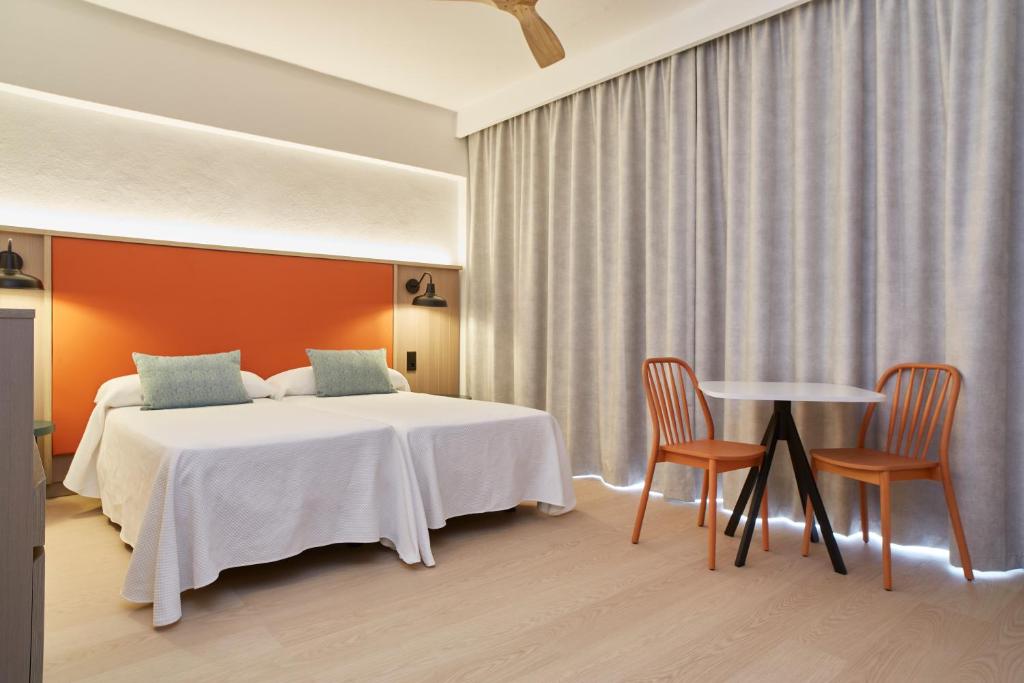 A bed or beds in a room at Excelsior Estudios & Apartamentos