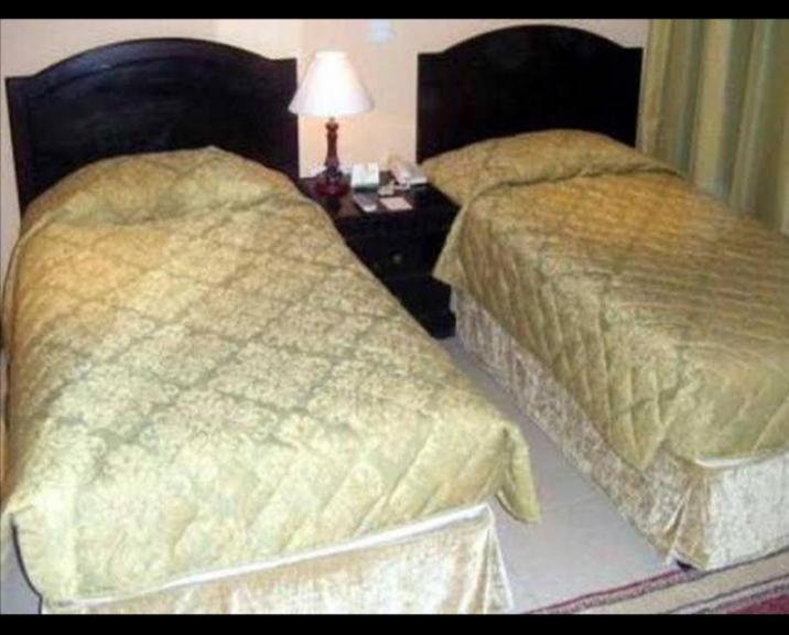 a hotel room with two beds and a table with a lamp at comfort zone for accommodation in Dubai