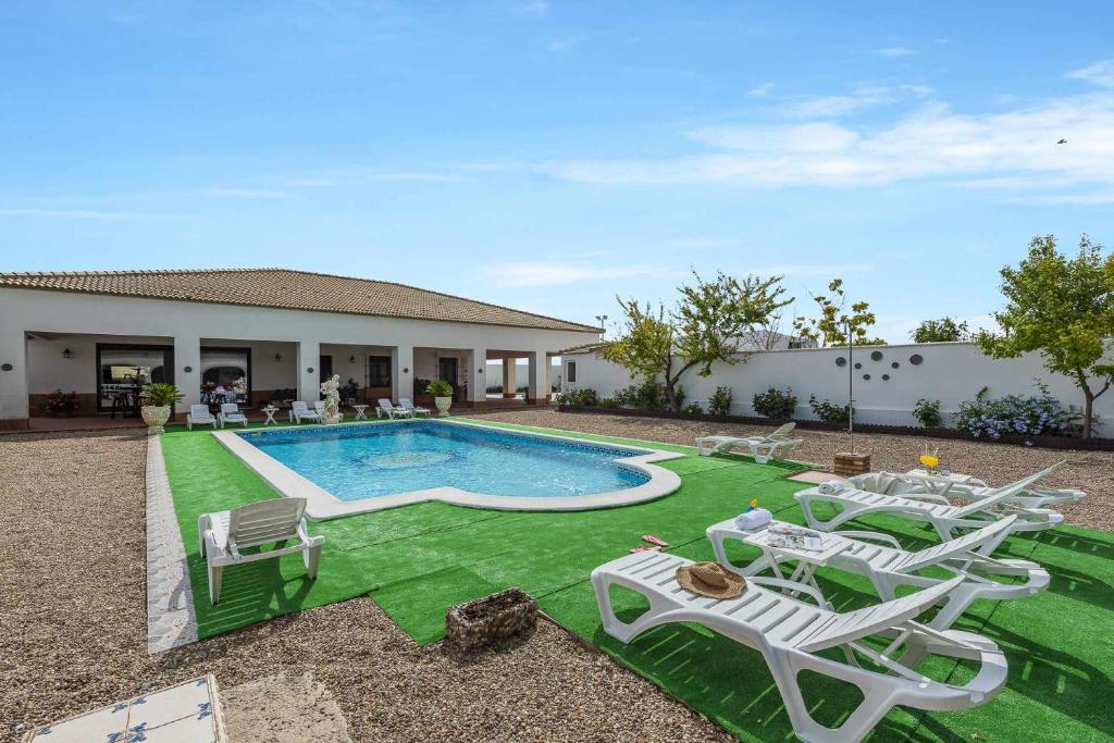 un cortile con piscina, sedie a sdraio e piscina di Casa Rural Villa Cerro Mena a La Lantejuela