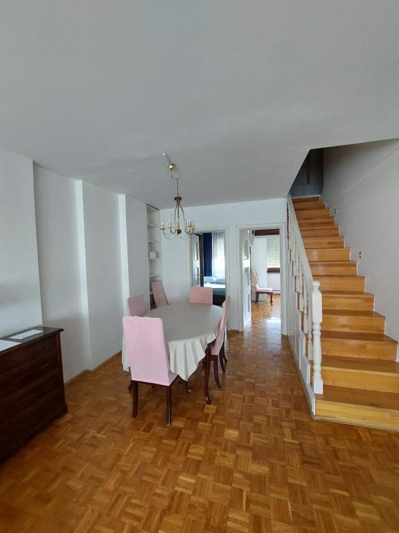 a dining room with a table and chairs and a staircase at Apartman LAURA in Zagreb