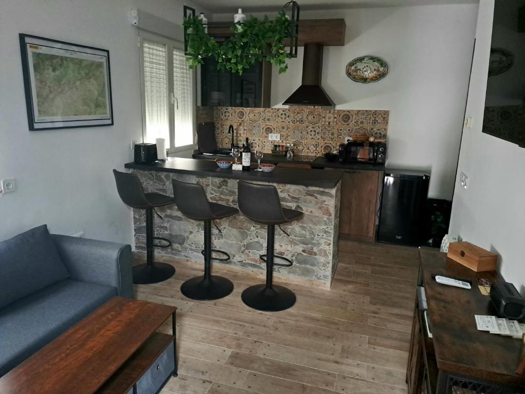 a kitchen with a bar with stools in front of a fireplace at Casa El Frenazo 