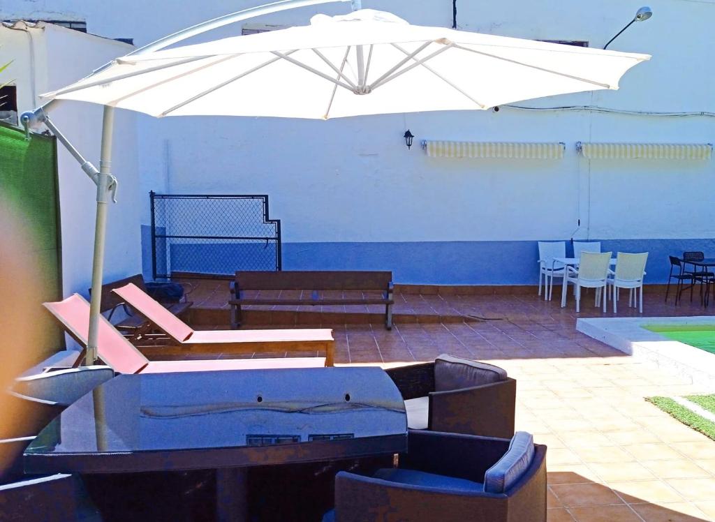- un grand parasol blanc dans une chambre avec des tables et des chaises dans l'établissement El Salao, à Olvera