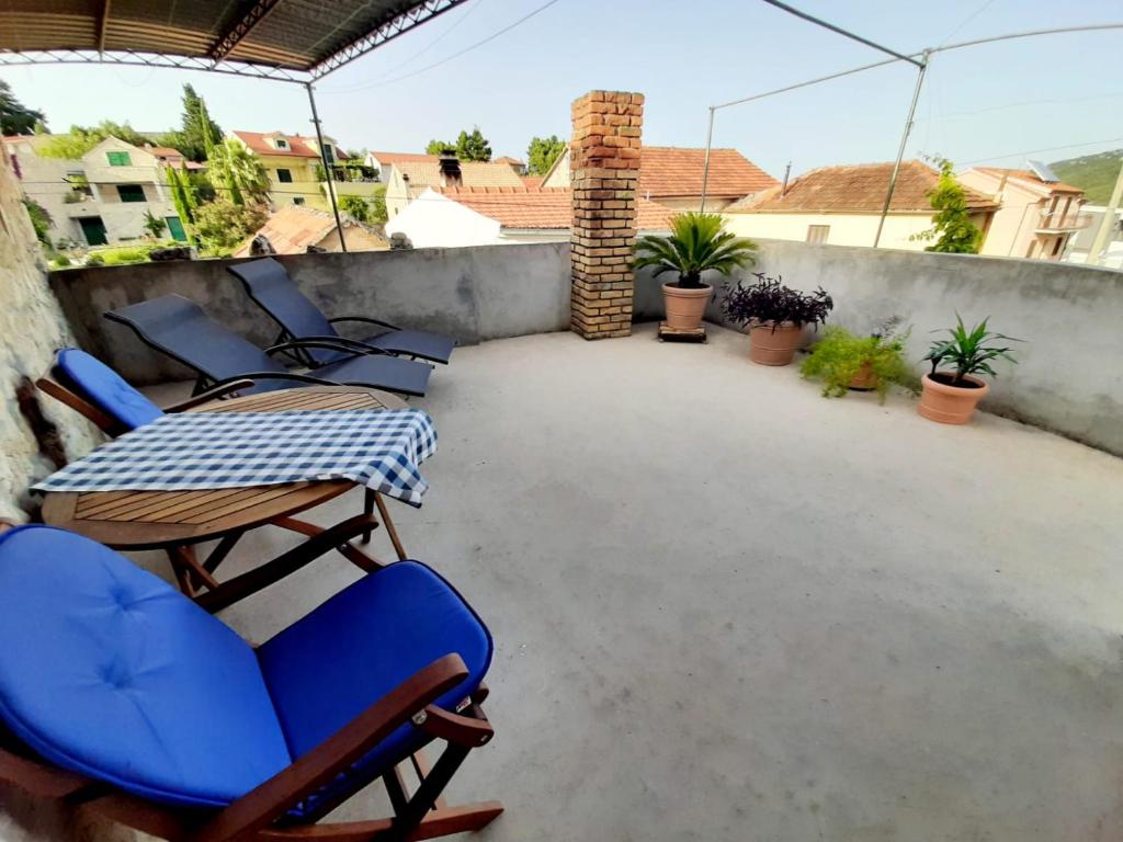 eine Terrasse mit Stühlen und einem Tisch auf dem Balkon in der Unterkunft Vacation House Calluna in Vrisnik