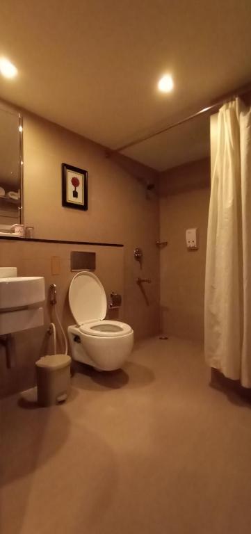 a bathroom with a toilet and a sink at SVN GRAND in Kākināda