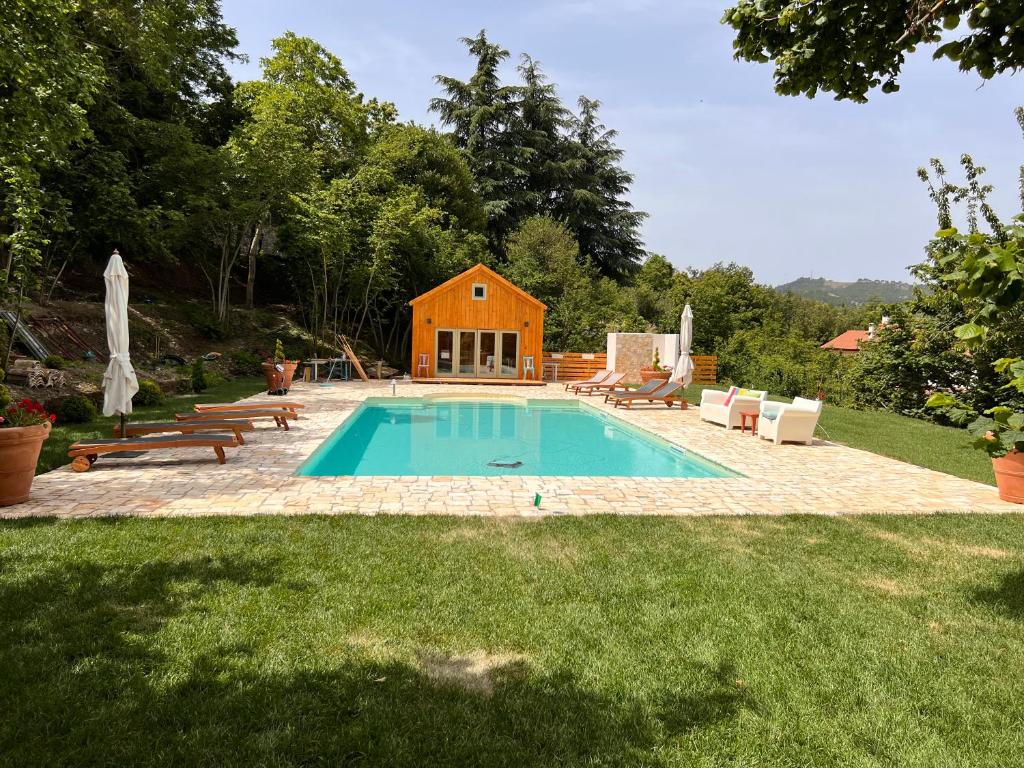 a swimming pool in a yard with a house at Hotel La Capannina in Aritzo