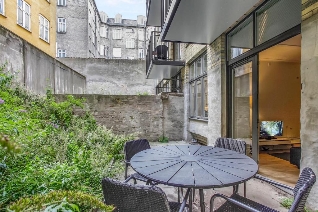 a patio with a table with chairs and an umbrella at City Center Apartments 739 in Copenhagen