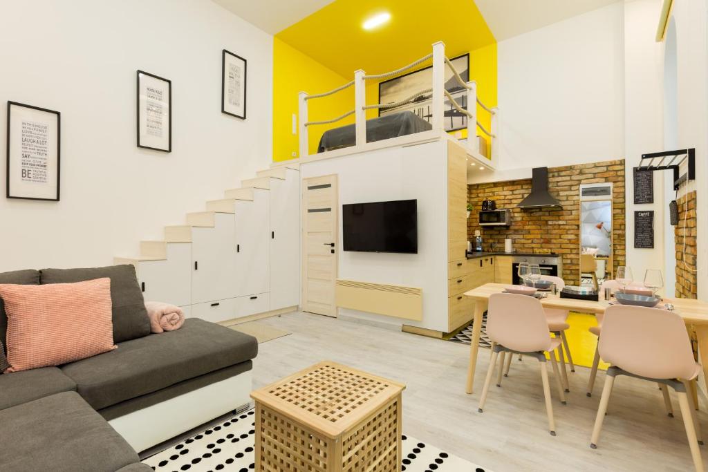 a living room with a couch and a loft at Pastel paradise with a ray of sunshine in Budapest