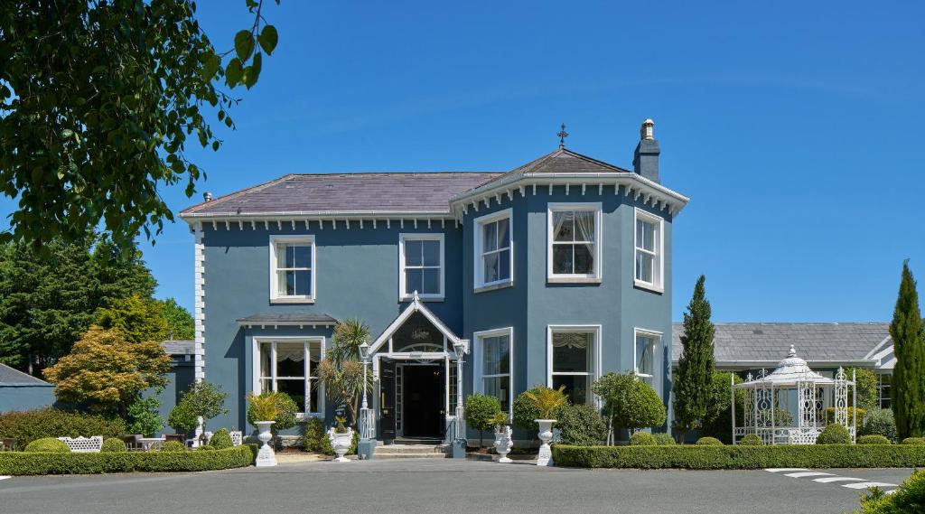 ein großes blaues Haus mit einem Vorgarten in der Unterkunft Summerhill House Hotel in Enniskerry