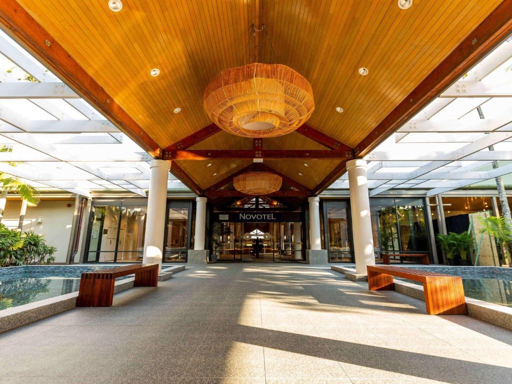 a lobby of a building with benches and a large ceiling at Novotel Sunshine Coast Resort in Twin Waters