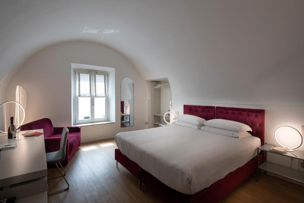 a bedroom with a large bed with a red headboard at Le Stanze Del Savonarola in Ferrara