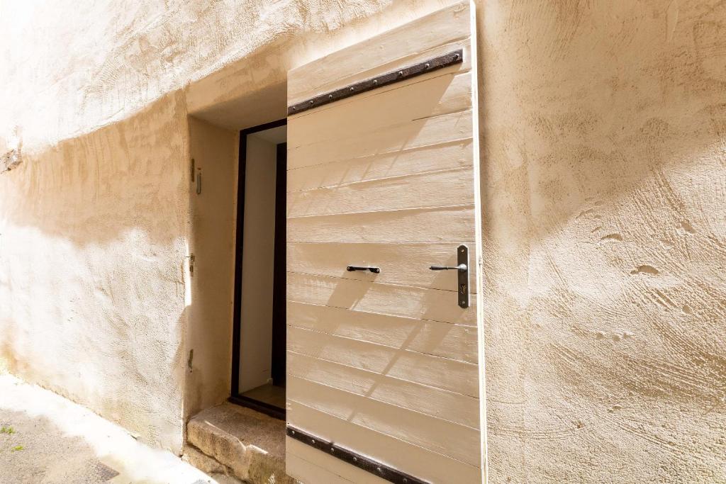 a door in the side of a building with a mirror at Studio Meuble Pied Du Ventoux in Malaucène