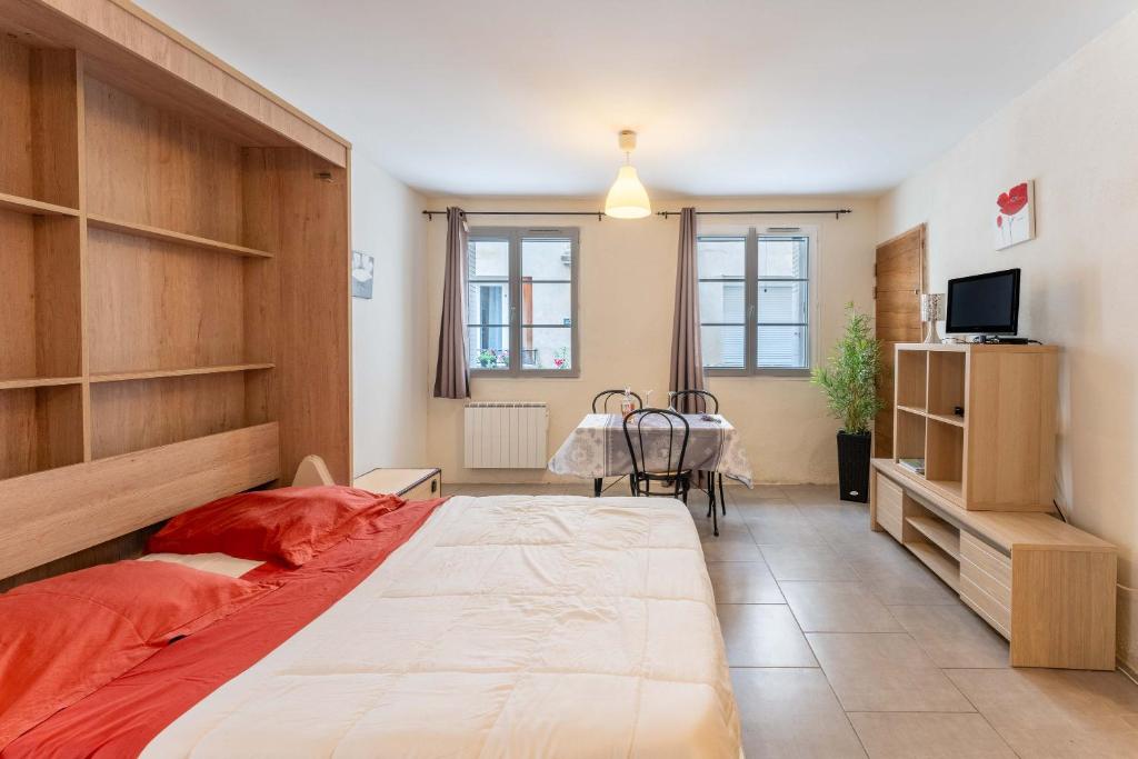 a bedroom with a large bed and a table at Studio Meuble Pied Du Ventoux in Malaucène