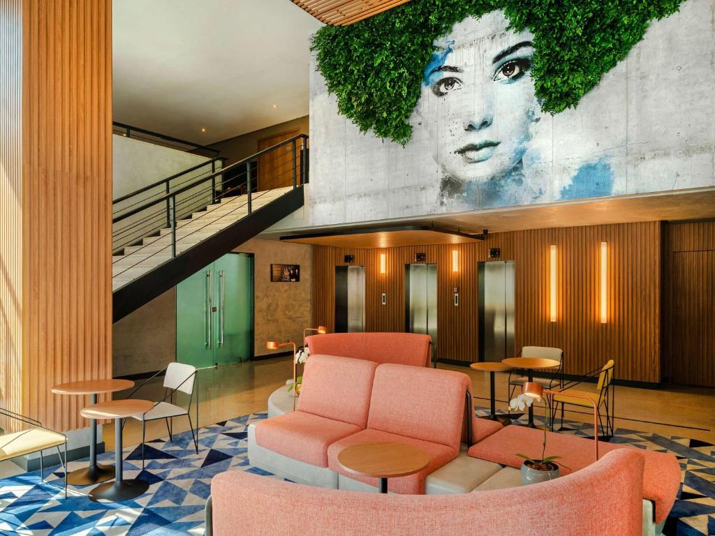 a lobby with a large mural of a woman at Novotel SP Jardins in São Paulo