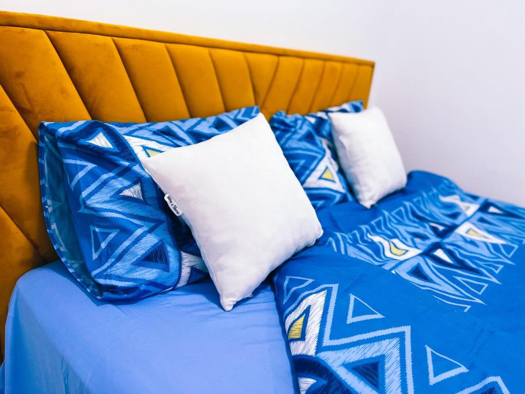 The Trendy Terrace في ستيب: سرير عليه وسائد زرقاء وبيضاء