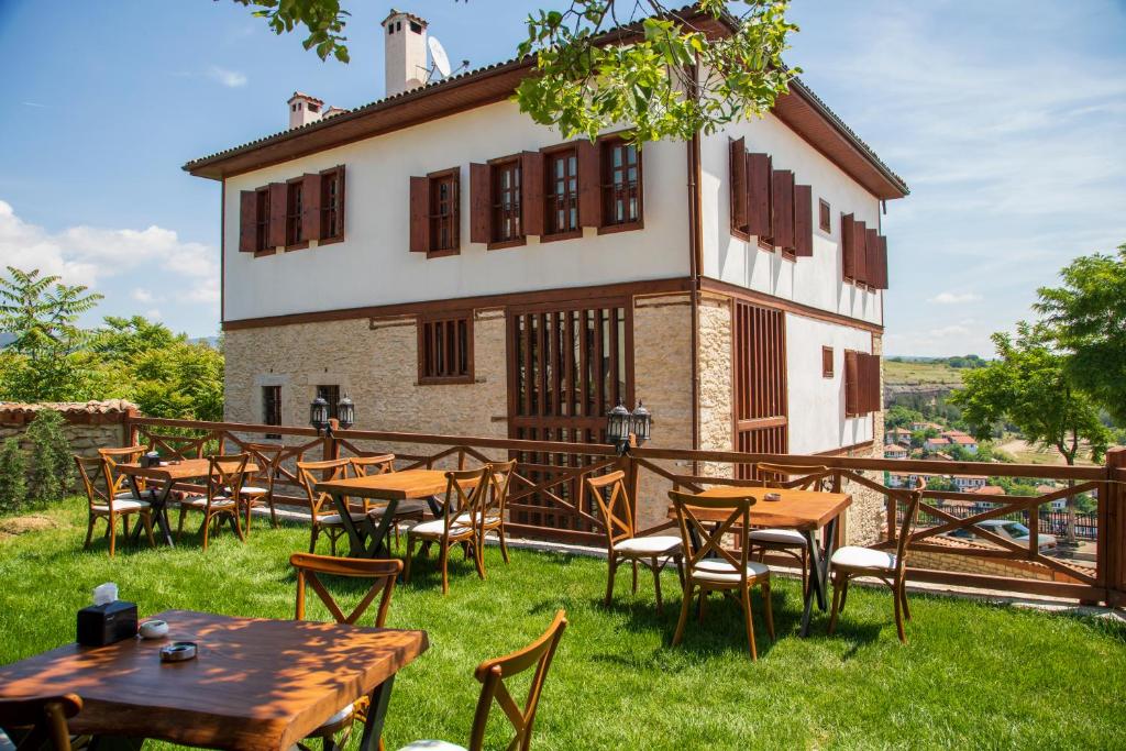 um grupo de mesas e cadeiras em frente a um edifício em Saffronia1900 Butik Otel em Saframbolu