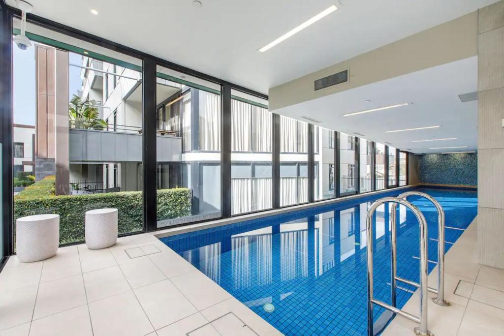 einen Pool in einem Gebäude mit Fenstern in der Unterkunft Beautiful 2BR APT with Balcony Pool and Gym in Melbourne