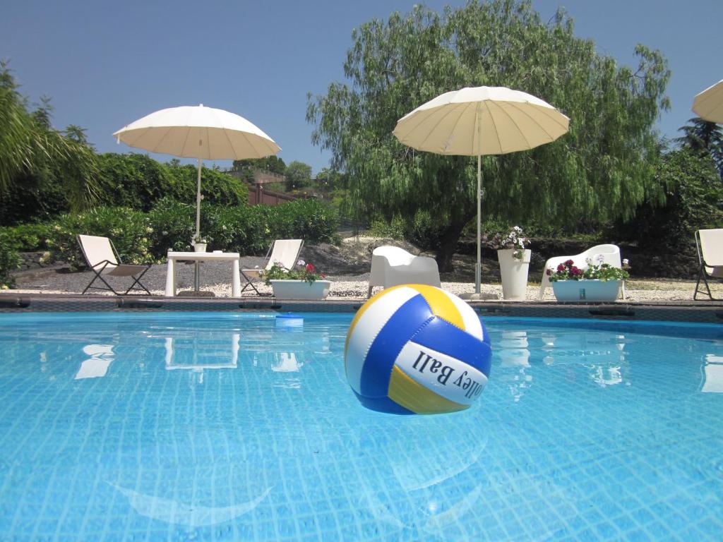 a blue and yellow volley ball in a swimming pool at B&B BOUTIQUE DI CHARME "ETNA-RELAX-NATURA" in Zafferana Etnea