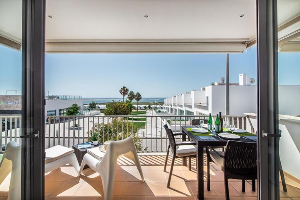 a balcony with a table and chairs and a view of the ocean at Apartamento Vista Mar - Arte Nova Fuseta in Fuzeta