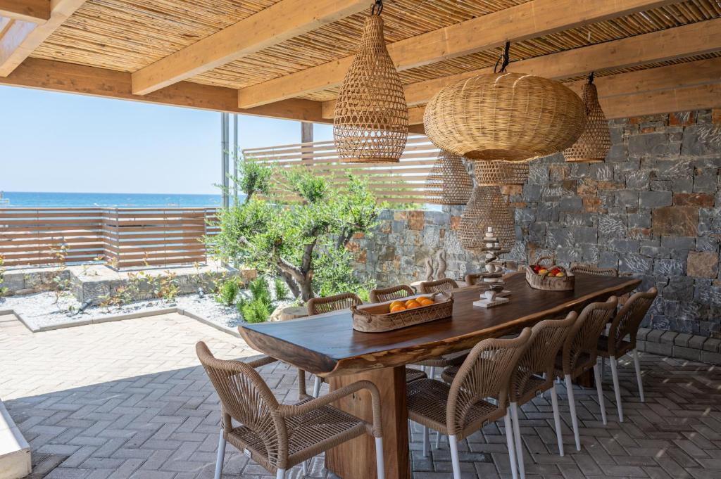 a dining room with a wooden table and chairs at Mnḗmē Suites & Villas in Kastrí