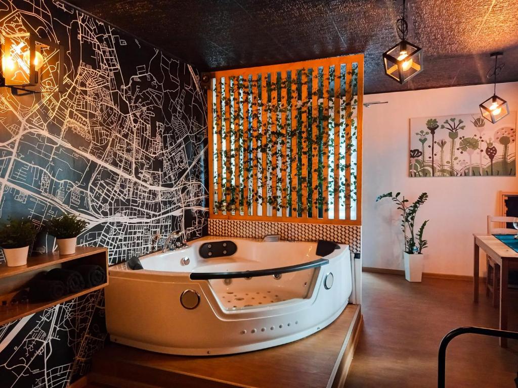 een hot tub in een kamer met een muur bedekt met graffiti bij Punkt Nieruchomości in Katowice