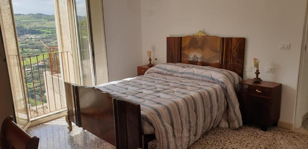 1 dormitorio con cama y ventana grande en Casa di Sissi en Monterosso Almo
