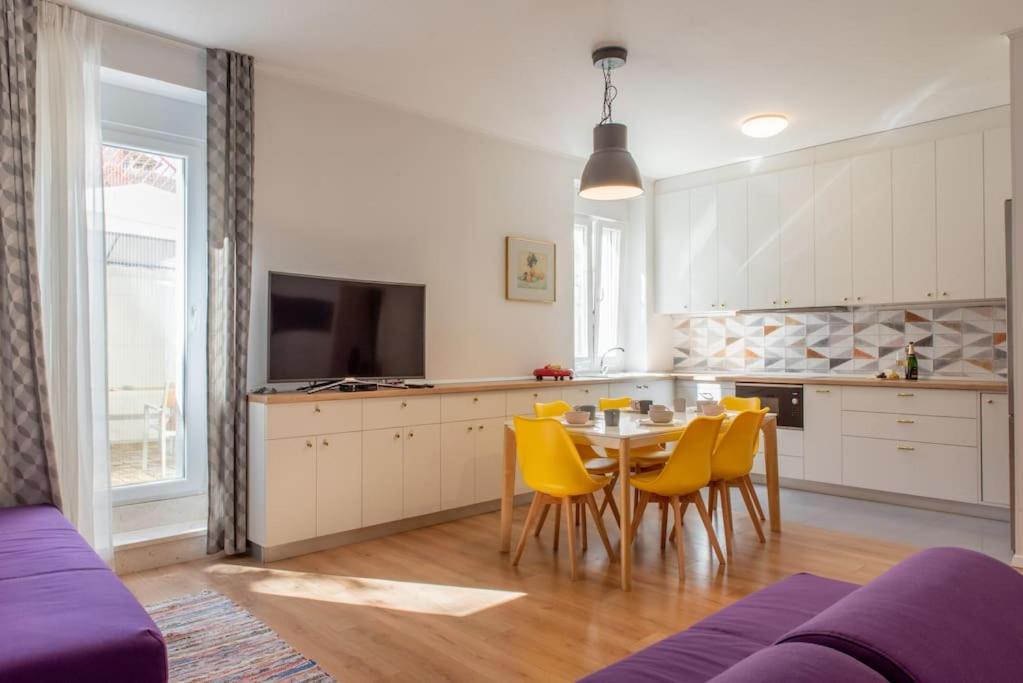 a kitchen with a dining table and yellow chairs at Girolamo Contarini Apartment in Split