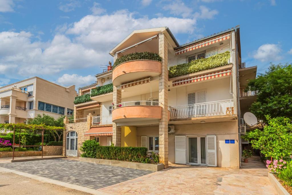 un edificio de apartamentos con balcones y plantas en Apartments Daniela, en Makarska