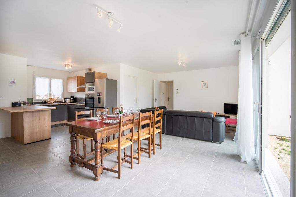 cocina y sala de estar con mesa y sillas en Entre lacs & Océan - Maison climatisée avec jardin, en Vielle-Saint-Girons