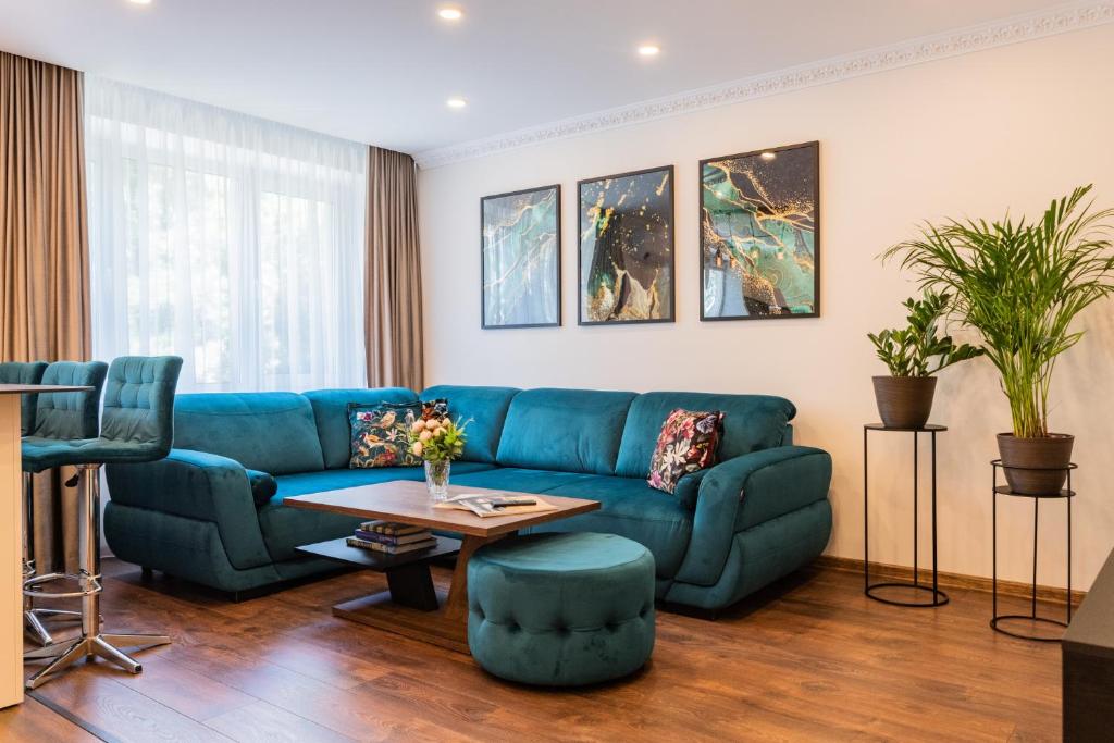 a living room with a blue couch and a table at E. D. Elite Apartment in Šiauliai