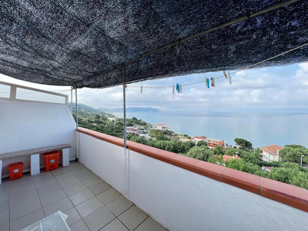 een balkon met een groot raam met uitzicht op de oceaan bij Appartamenti Villa Verde in Caprioli