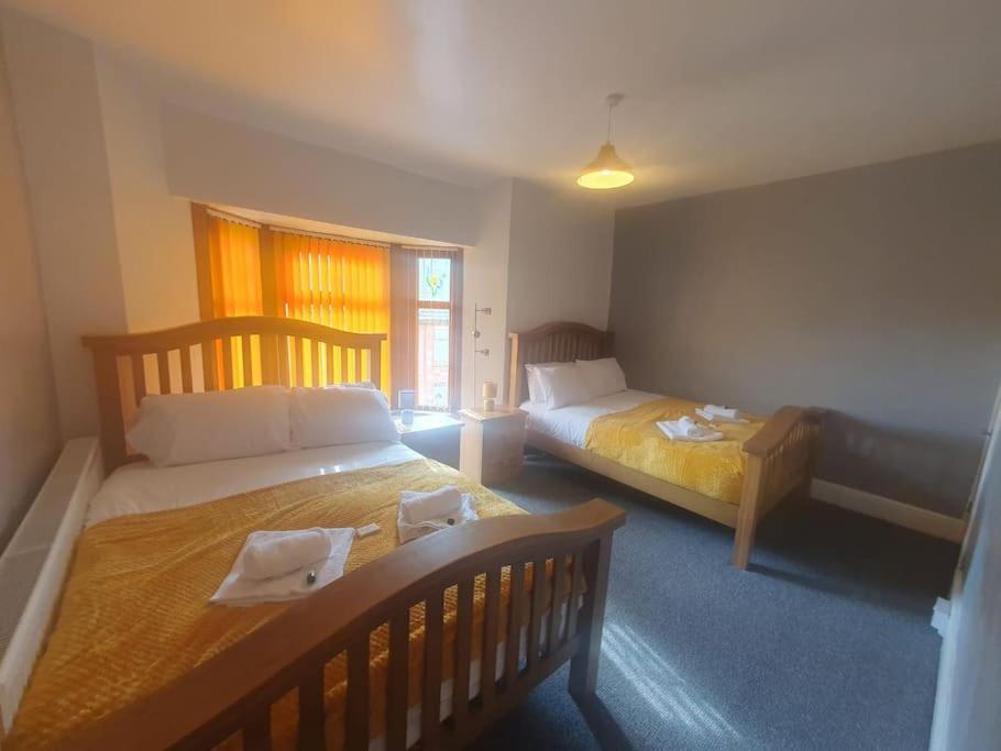 een slaapkamer met 2 bedden en een raam bij Guardian View in Abertillery
