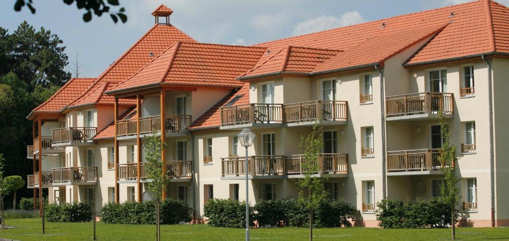 a large building with red tile roofs at Résidence VTF Les Allées du Green in Levernois