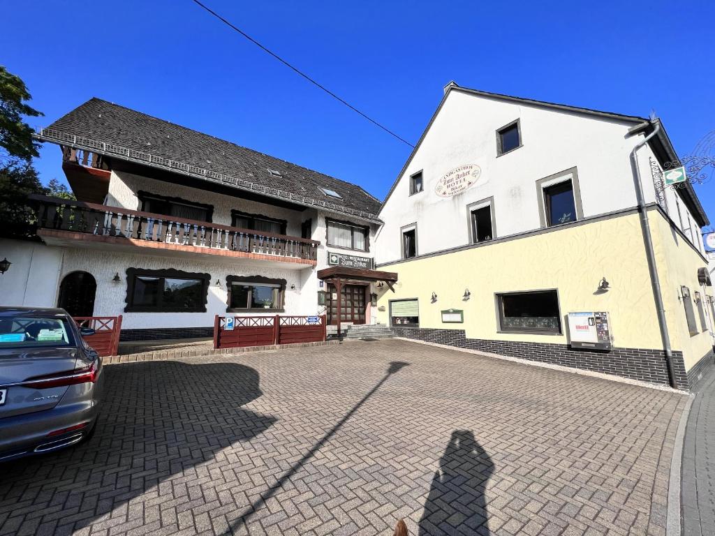 Landgasthof Zum Anker في Langenfeld: شخص واقف امام مبنى