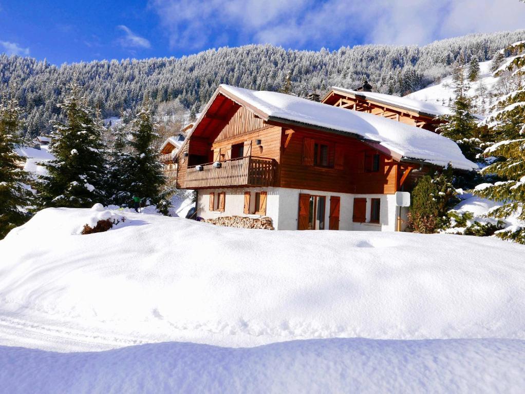 una casa nella neve con un mucchio di neve di Chalet L'oréade a Manigod