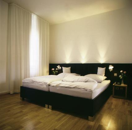 um quarto com uma cama grande e lençóis brancos em Hotel Lorenz em Essen
