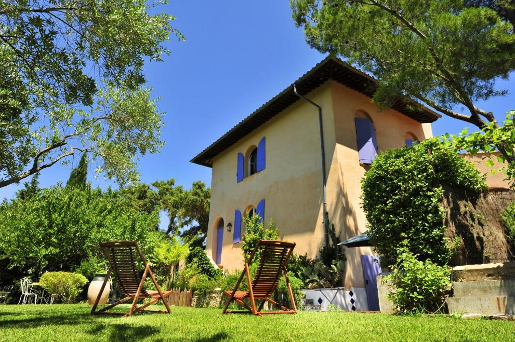 twee ligstoelen voor een huis bij Le Mazet des Mûres in Grimaud