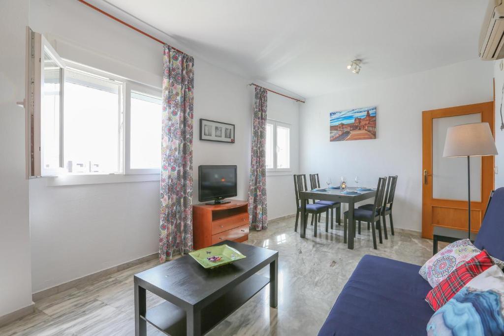 a living room with a couch and a tv and a table at Azahar Fibes in Seville