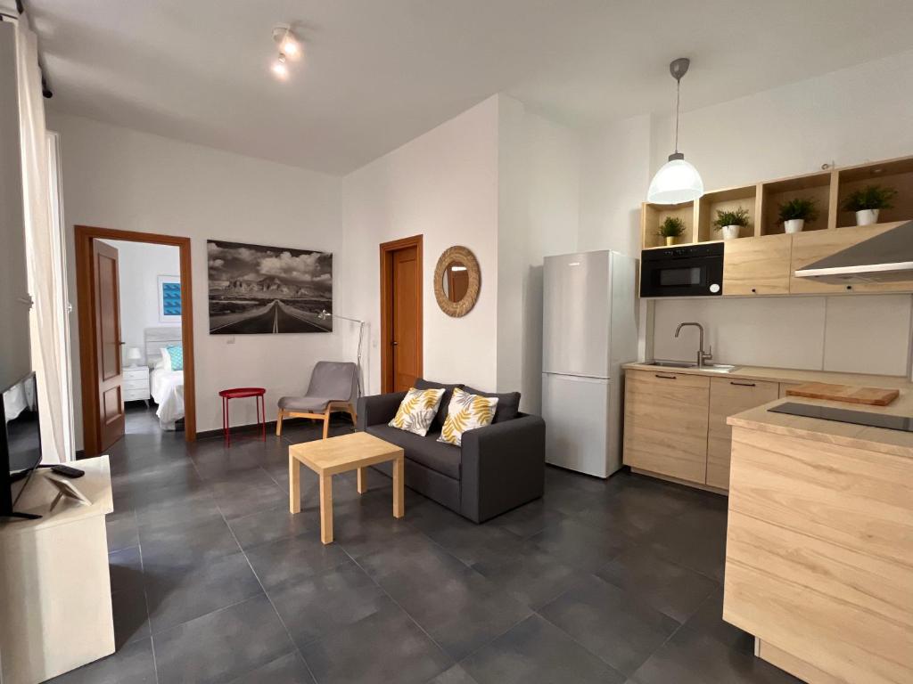 a kitchen and living room with a couch and a refrigerator at MALAGA CENTRO CATEDRAL in Málaga