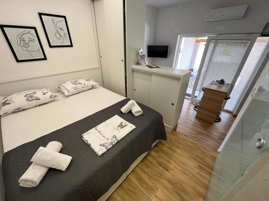 a bedroom with a bed and a desk and a window at Studio apartman Oliva in Vodice