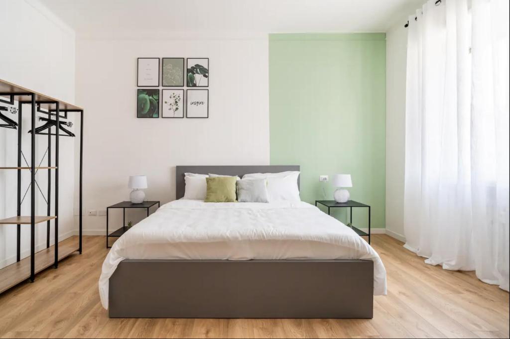 een slaapkamer met een groot bed en 2 bijzettafels bij Beno House Brescia in Brescia