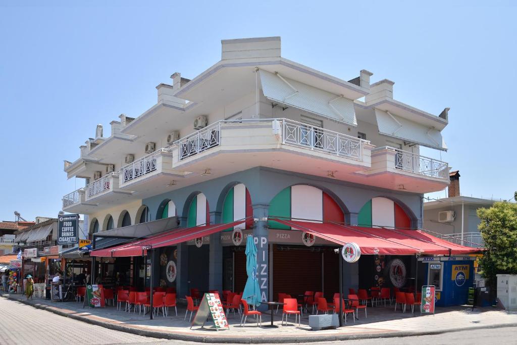 a building with tables and chairs in front of it at Villa Matina in Leptokarya