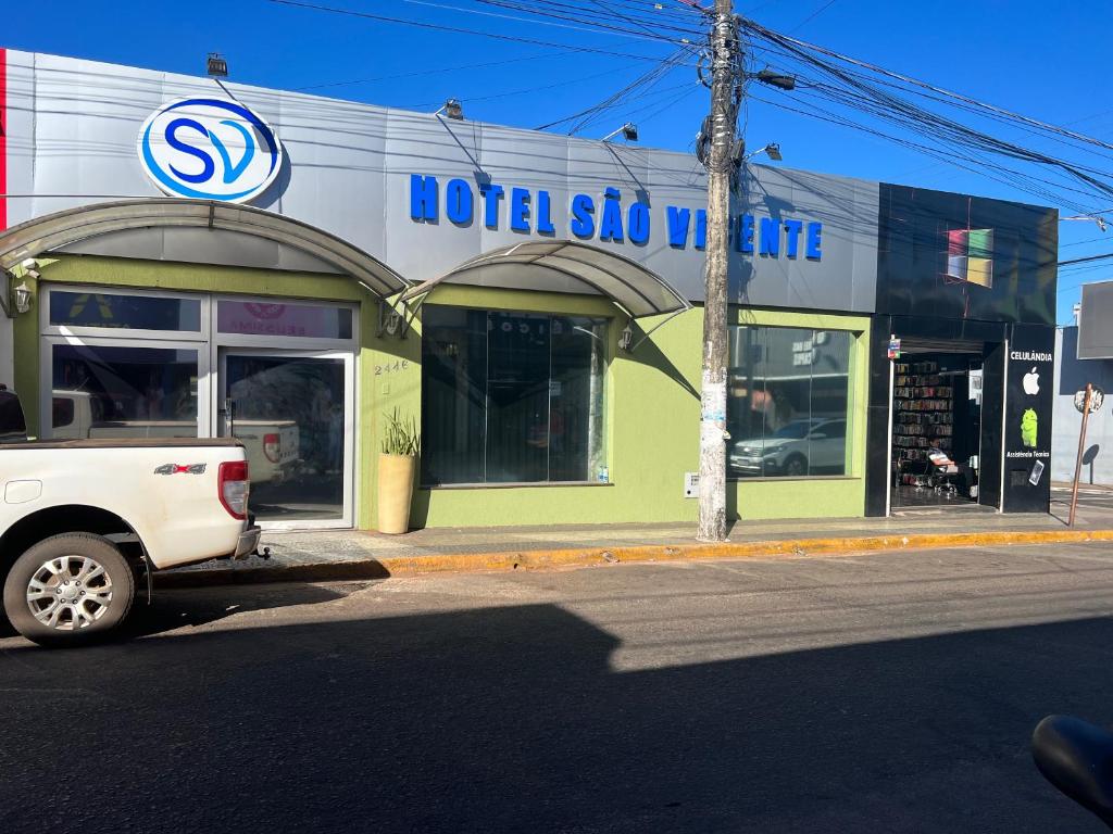 uma carrinha do hotel estacionada em frente a uma loja em Hotel São Vicente em Araguaína