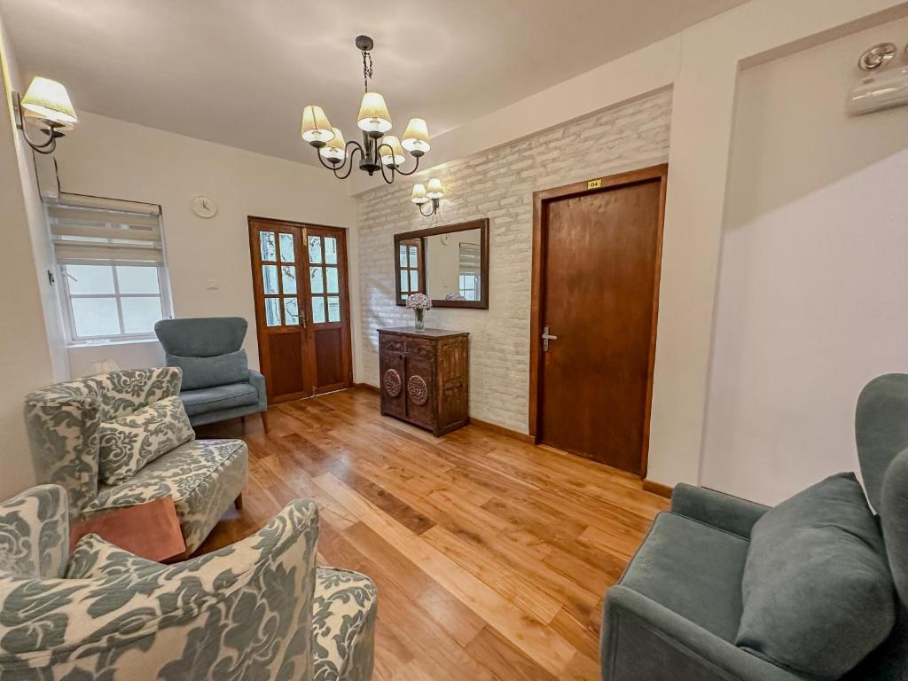 a living room with couches and a wooden floor at Grace in Nuwara Eliya