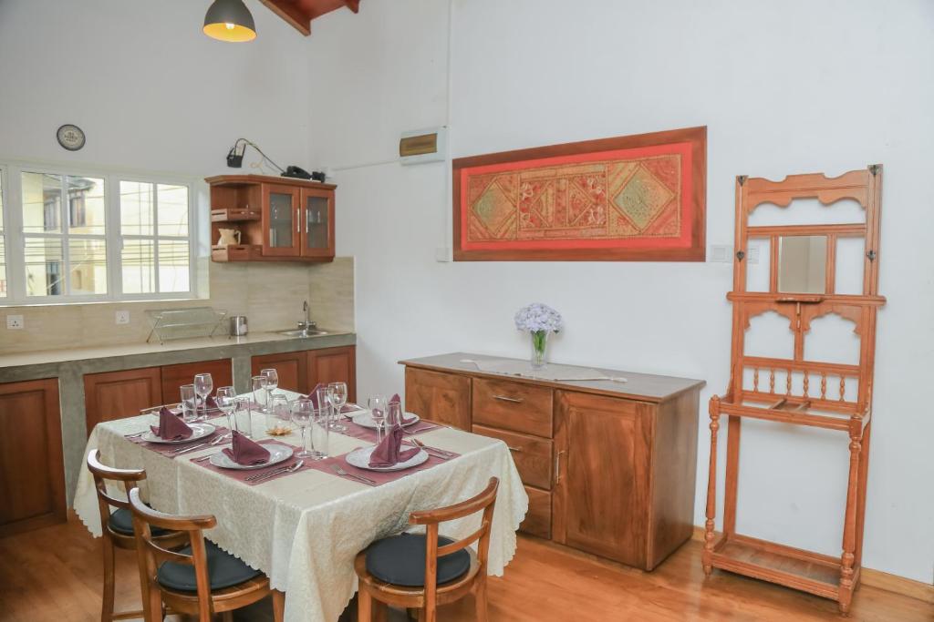 a kitchen with a table and some chairs and a table and a kitchen at Grace in Nuwara Eliya